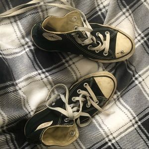 Extremely worn black and white high top converse